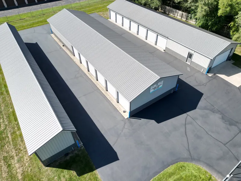 A high aerial shot of the storage facility showing the full layout and surrounding grass and trees