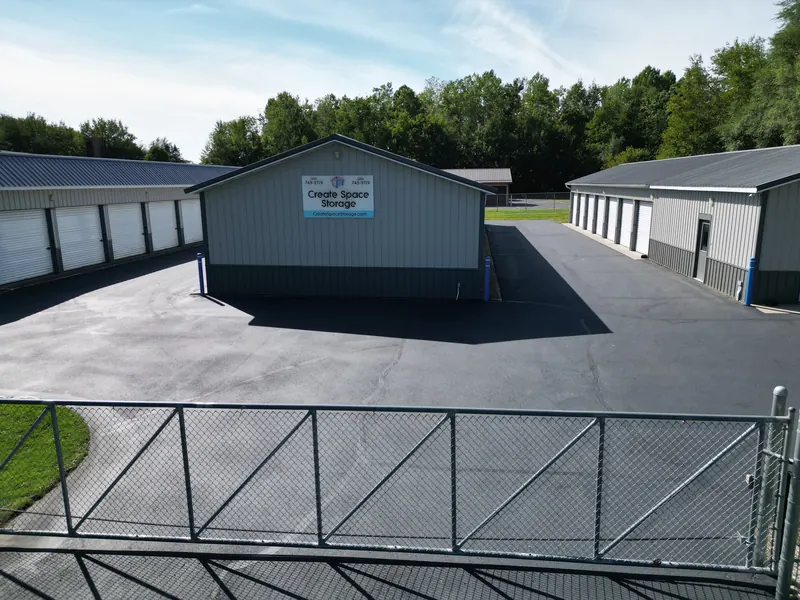 The central courtyard at Create Space Self Storage with the branded sign building between two unit rows