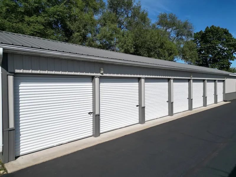 Wide drive-up storage units with tall roll-up doors and paved access for trucks and trailers